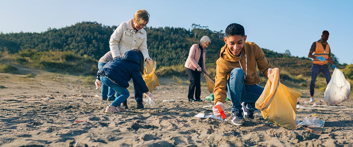 people picking up trash on a beach